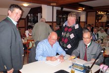 Foto (von Wilhelm Frickh): Für Bürgermeister Michael Altmann aus Redleiten signieren Martin Kaiser und Erwin ein Buch. (v.l)